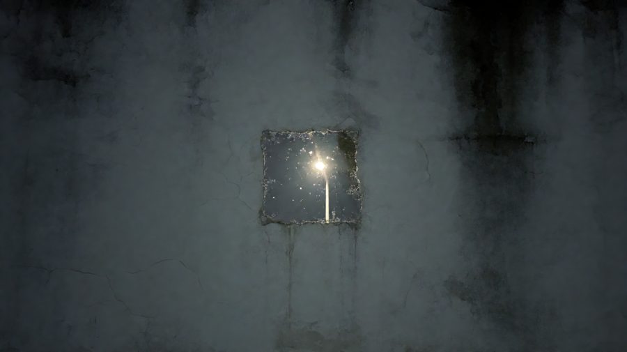 墙上留浅方形雨痕，雨落停驻，映出摇晃路灯